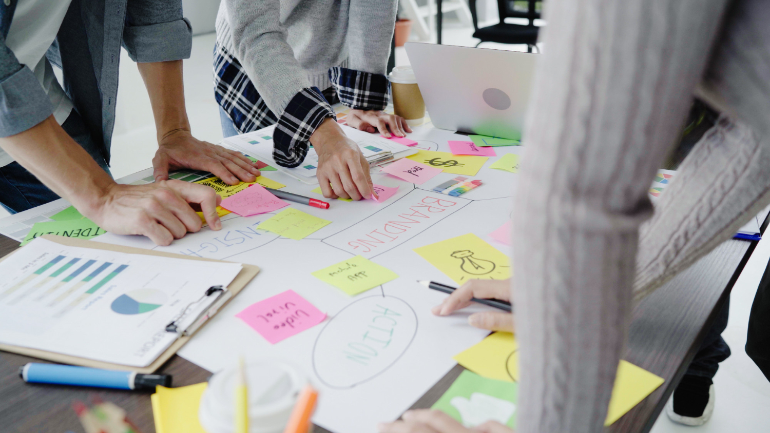 A diverse group of people collaborating on a project, surrounded by colorful sticky notes on a table
